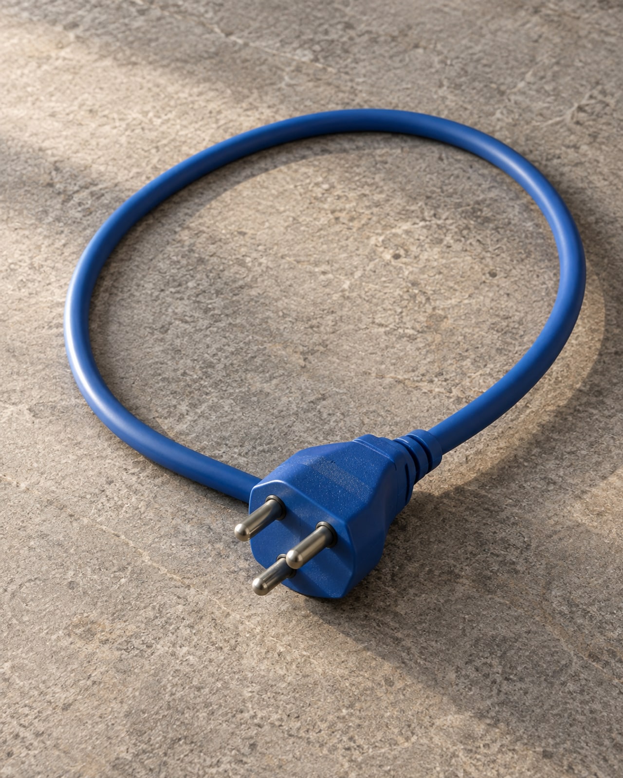Imagem ilustrativa: Detalhe conceitual de cabo elétrico azul enrolado com conector sem marca